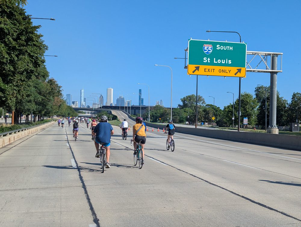 Cyclists riding on Lake Shore Drive under an I-55 sign