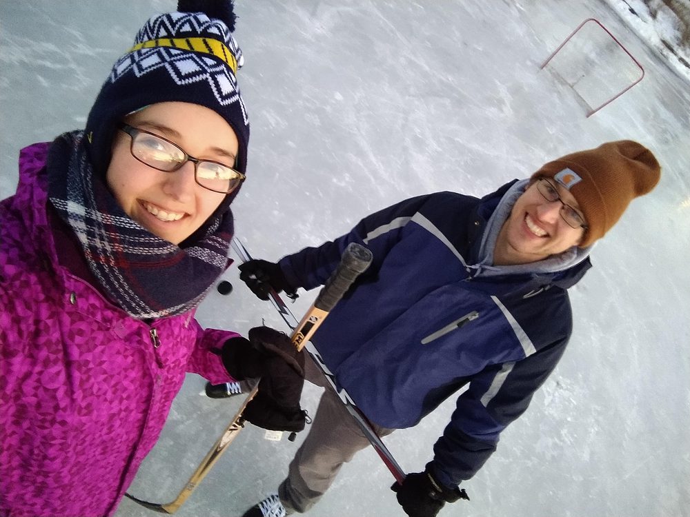 Luke and Katelyn ice skating, smiling up at the camera