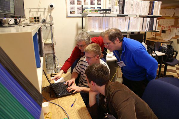 Luke and others gathered around a laptop in an observatory office