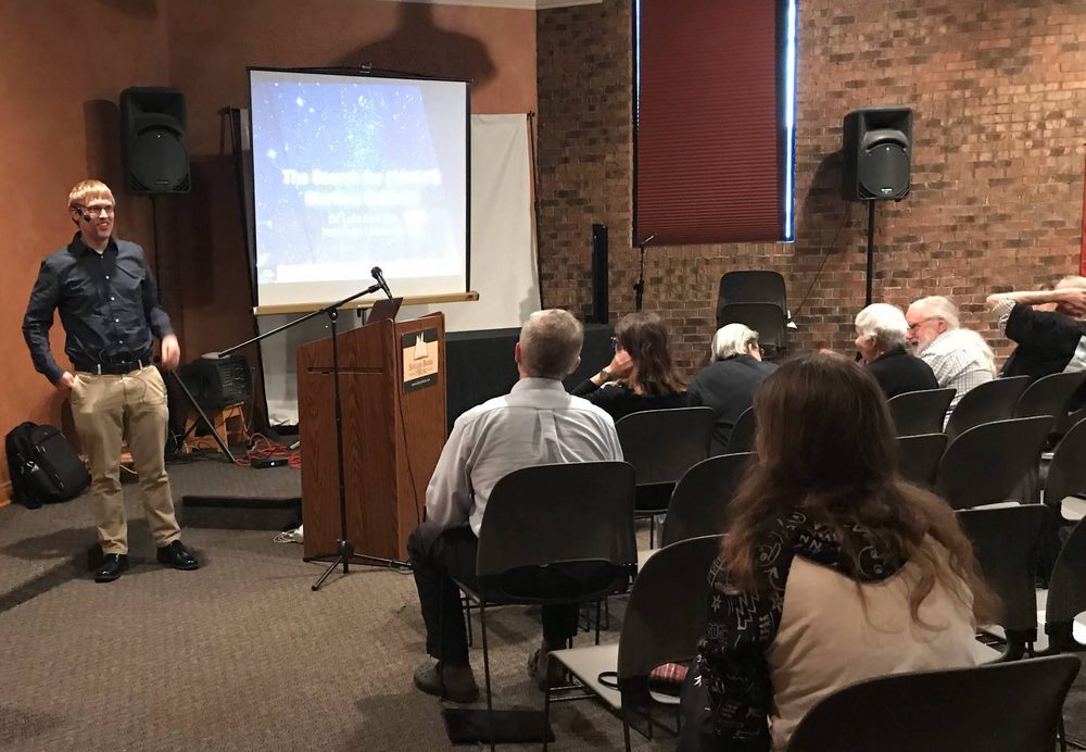 Luke giving a talk to a seated audience