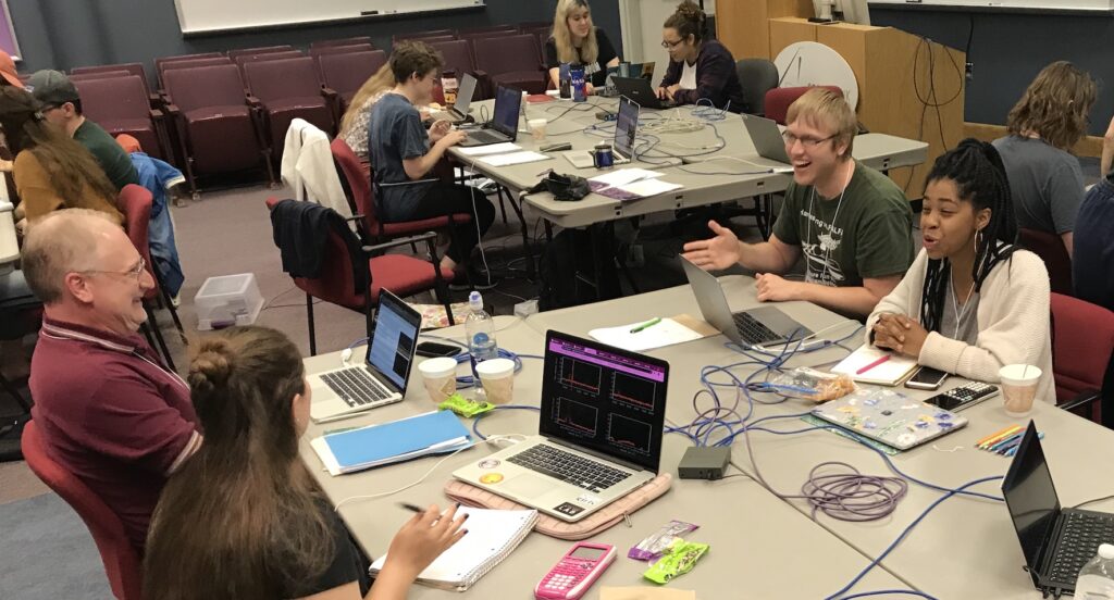 Dr. Leisman and participates working and laughing while analyzing data at a radio astronomy workshop at Green Bank Observatory.